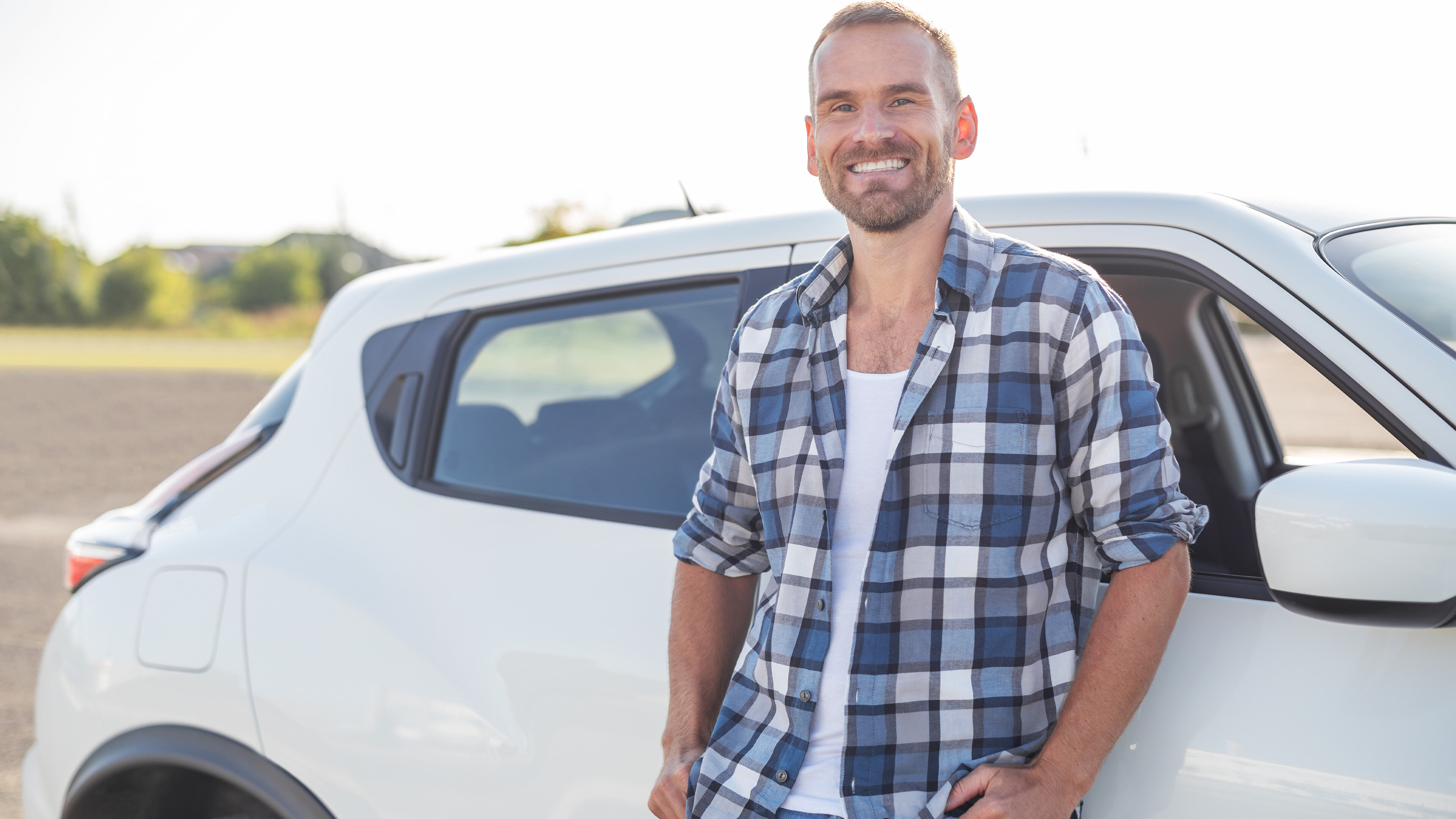 Jeune homme devant une voiture